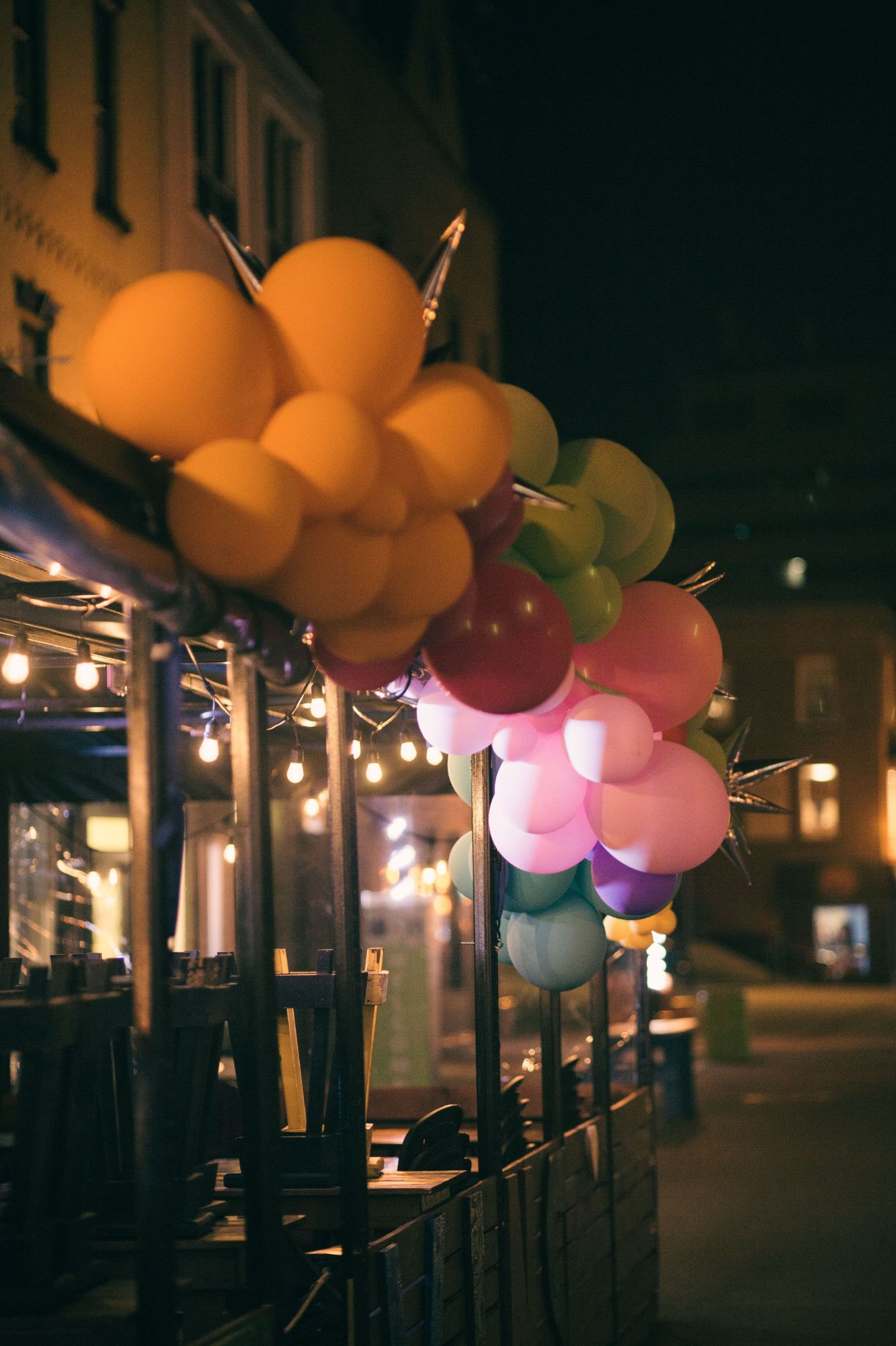 Décor de ballons colorés sur mesure en façade avec guirlandes lumineuses · Ballons déco · Personnalisation totale
